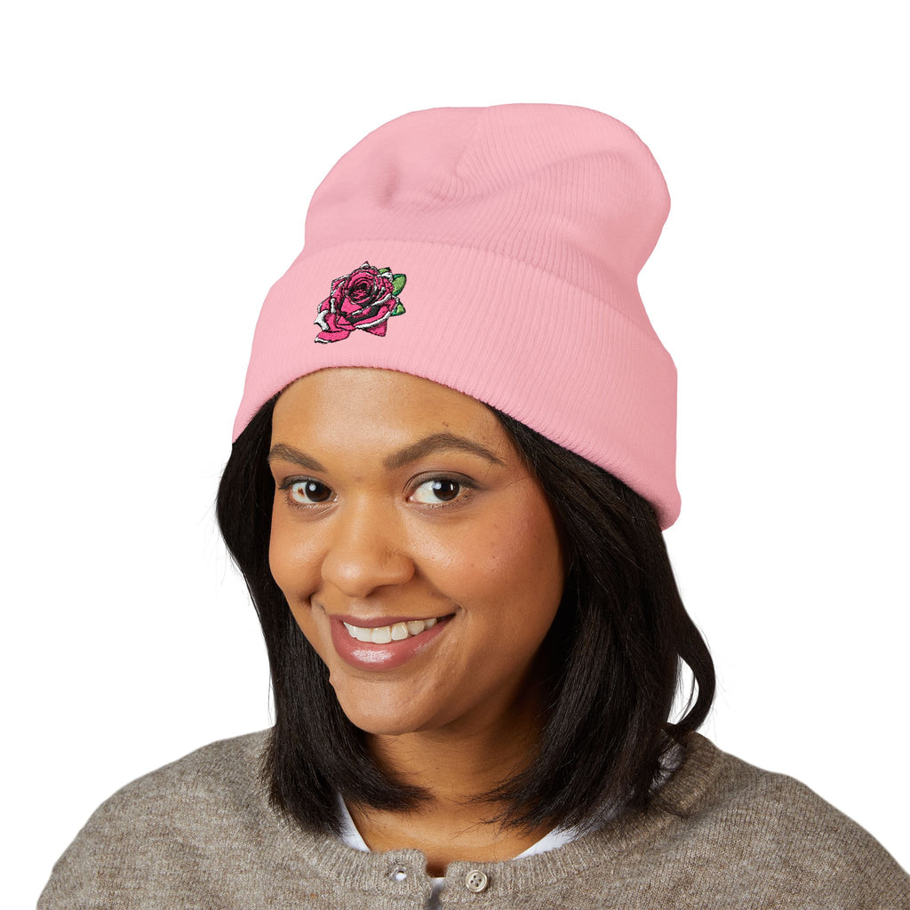 Person wearing a pink beanie with a logo on a white background