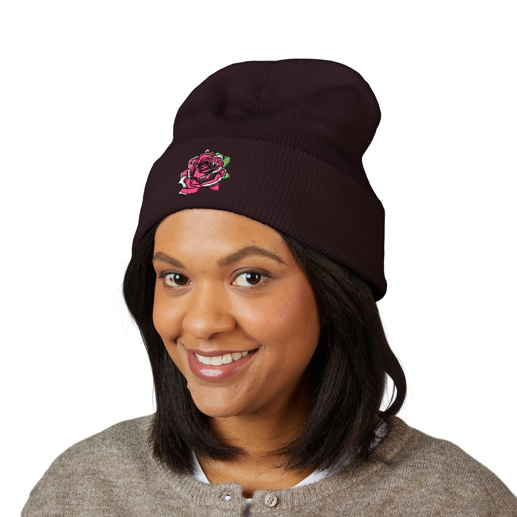Person wearing a navy beanie with a red and blue logo on a white background