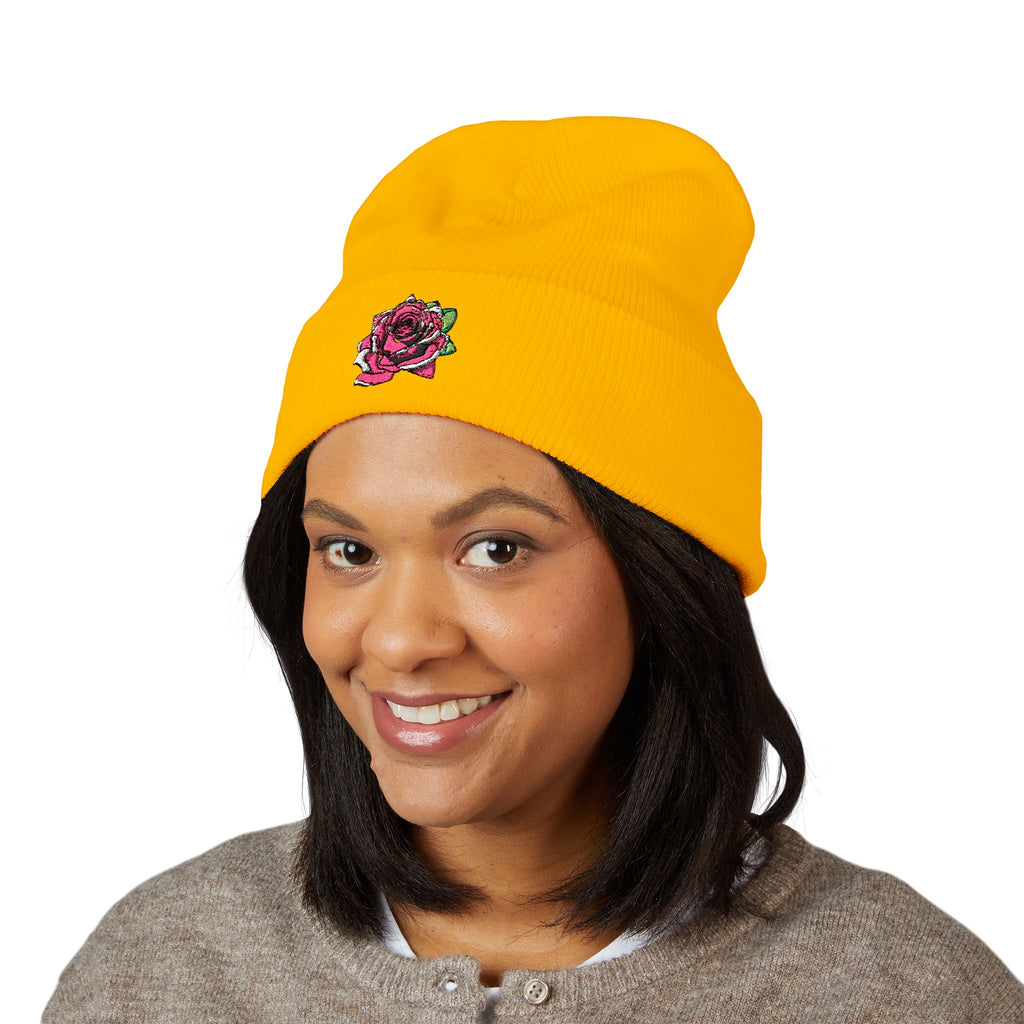 Person wearing a yellow beanie with a logo on a white background