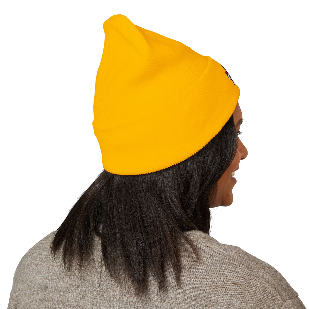 Person wearing a yellow beanie with a logo on a white background